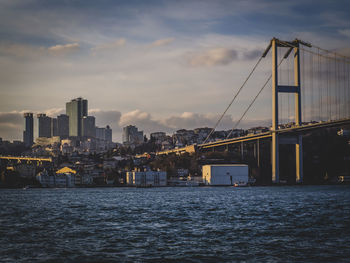 Bridge over sea against buildings in city