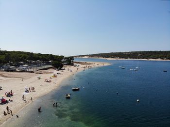 High angle view of people on beach against clear sky