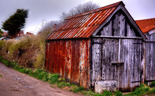 Exterior of abandoned house against sky