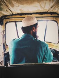 Rear view of man working in bus