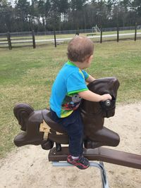 Rear view of two children sitting outdoors