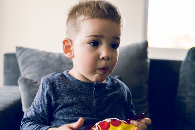 Cute boy eating food at home