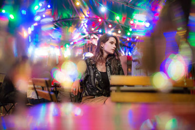 Woman sitting at party illuminated traditional clothing at night