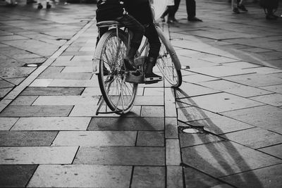 Low section of people riding bicycle on footpath