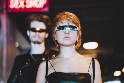 Young woman wearing smart glasses with boyfriend in background