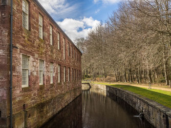 Canal amidst buildings against sky