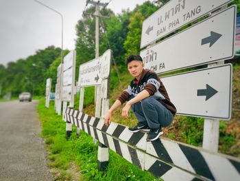 Portrait of boy on road against plants