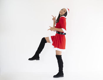 Full length of woman standing against white background