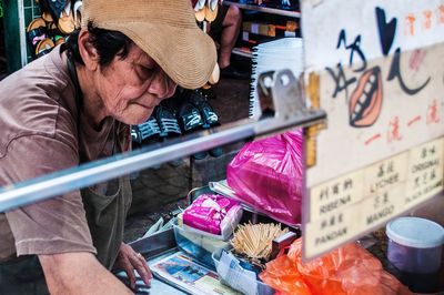Midsection of woman holding umbrella for sale at market stall