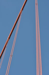 Low angle view of amusement park ride against clear blue sky