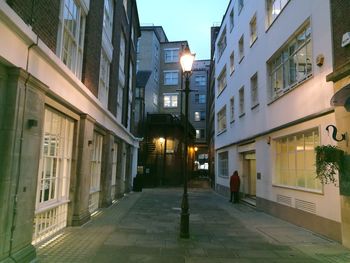 Street amidst illuminated city against clear sky