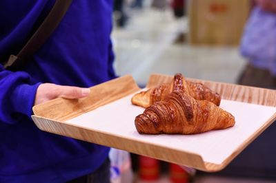 Close-up of hand holding bread on table