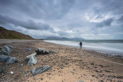 Scenic view of beach against cloudy sky