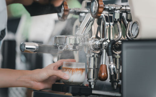 Cropped hand of man preparing coffee