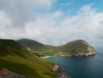 Scenic view of sea and mountains against sky