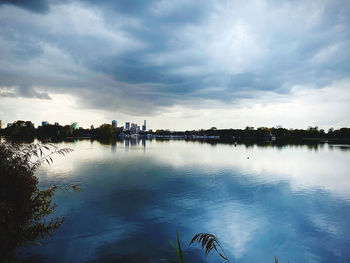 Scenic view of lake against sky in city