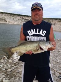 Portrait of mid adult man holding fish at lakeshore