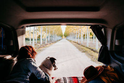 Woman with dog lying in camper trailer