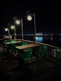 View of empty bench on street at night