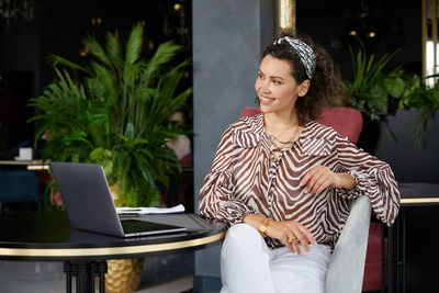 Portrait of young woman using laptop at home