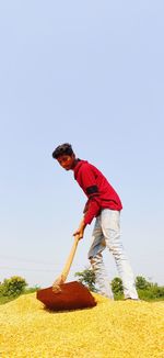 Side view of man standing against blue sky