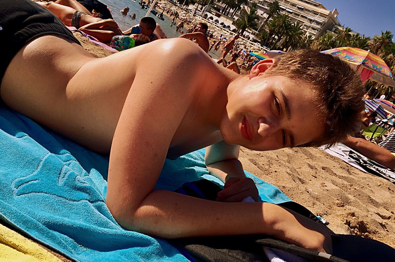 BOY LYING DOWN ON BEACH