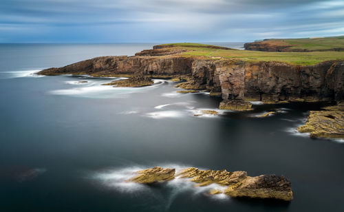 Scenic view of rocks in sea against sky