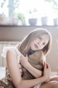 Portrait of young woman sitting on sofa at home