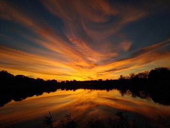Scenic view of lake against romantic sky at sunset