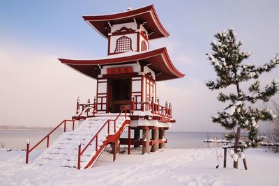 Lifeguard hut on snow covered field against sky