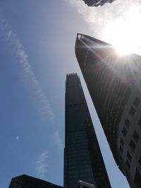 Low angle view of modern buildings against sky on sunny day