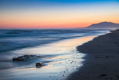 Scenic view of beach against sky during sunset