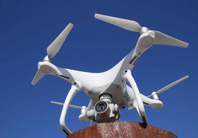 Low angle view of camera against clear blue sky