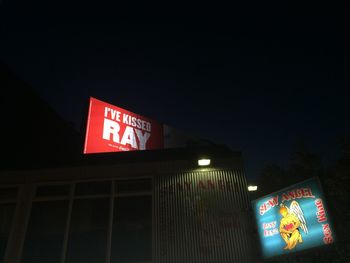 Low angle view of information sign at night