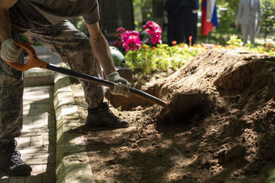 Man digs grave. guy with shovel digs ground. funeral details. work in cemetery.