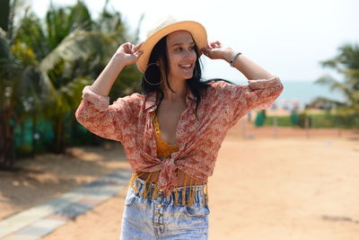 Portrait of young woman standing at beach