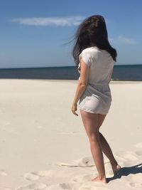 Woman walking at beach against sea