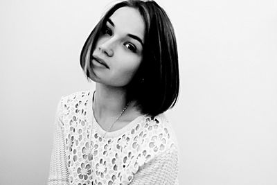 Close-up portrait of young woman against white background