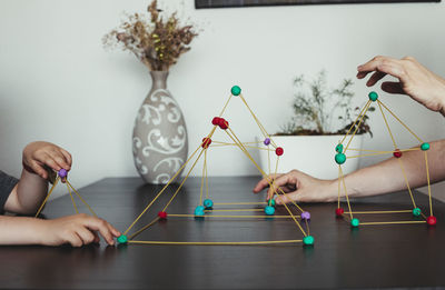 Mother and son making geometric shapes from sticks and play dough.