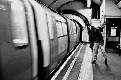 Happy woman screaming while standing at railroad station