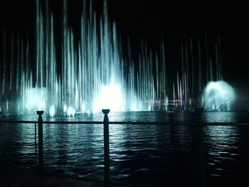 Panoramic view of people at sea against sky at night