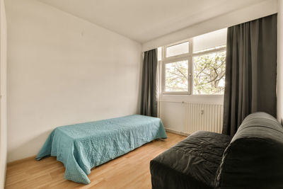 Rear view of woman sitting on bed at home