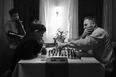 Father and son playing chess at home