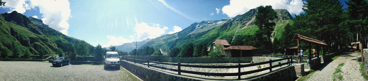 mountain, mountain range, sky, water, scenics, tranquility, tranquil scene, beauty in nature, panoramic, nature, tree, sunlight, lake, railing, idyllic, day, outdoors, incidental people, cloud - sky, river