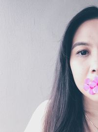 Cropped image of woman carrying flowers in mouth