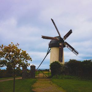 Traditional windmill on field against sky