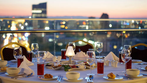 Wine bottles on table at restaurant against sky during sunset