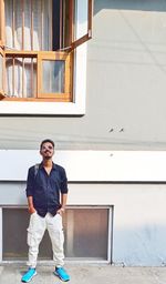 Full length of young man standing against building