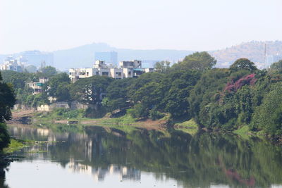 Scenic view of lake by buildings against sky