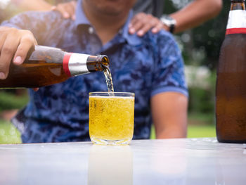 Beer bottle with a glass on a white table, friendship and celebration concept.